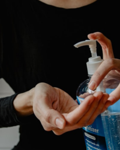Close up of a woman pumping hand sanitizer onto her hand